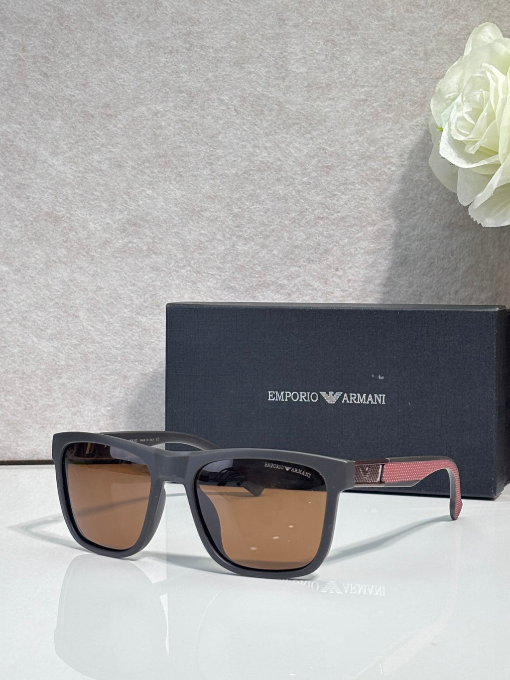 Designer glasses with gray frames, brown tinted lenses, and multicolor temple detail