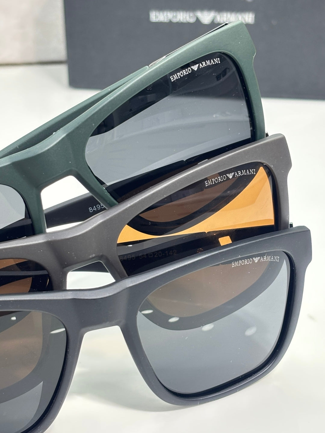 Designer glasses side view with green frames and patterned temple, dark lenses