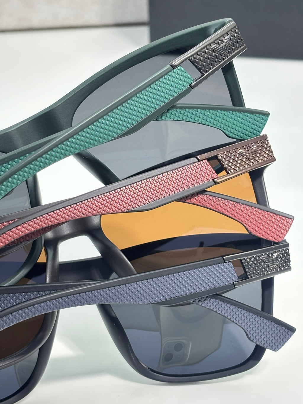 Eyeglasses temple close-up with teal, red, and gray textured bands and metal tips