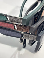 Eyeglass temple detail with textured metal hinge and teal, red, and gray accents