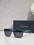 Designer glasses with gray frames, dark lenses, and green temple accents