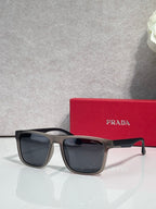 Prada sunglasses with dark navy frames and smoky black lenses on reflective surface