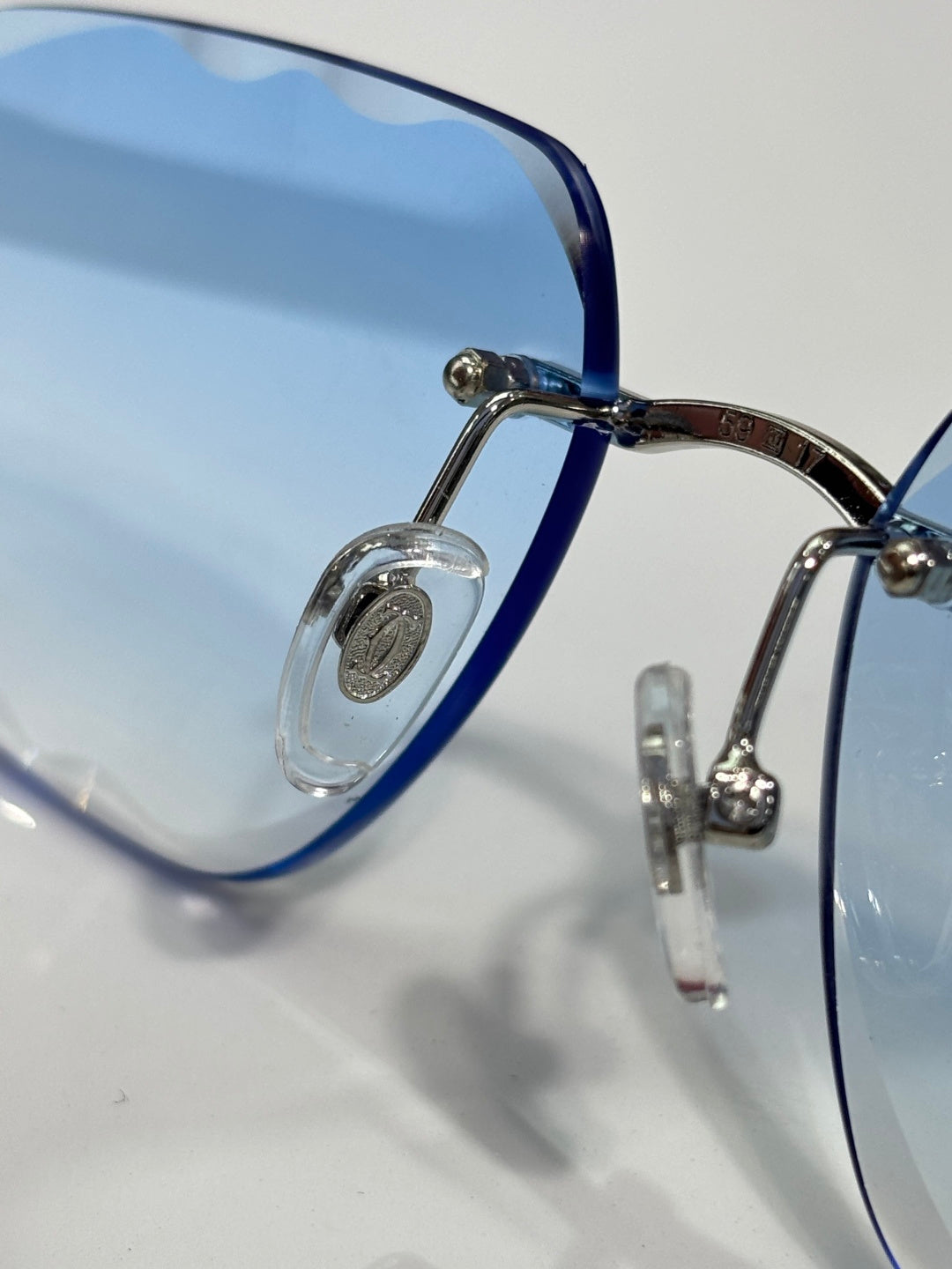 Cartier eyeglasses close-up, blue temples, metal hinges, clear lenses