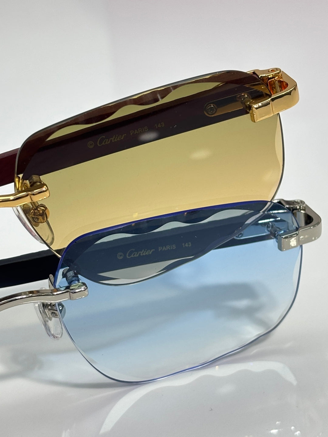 Cartier eyeglasses close-up, brown top rim, gold hardware, blue-tinted lenses