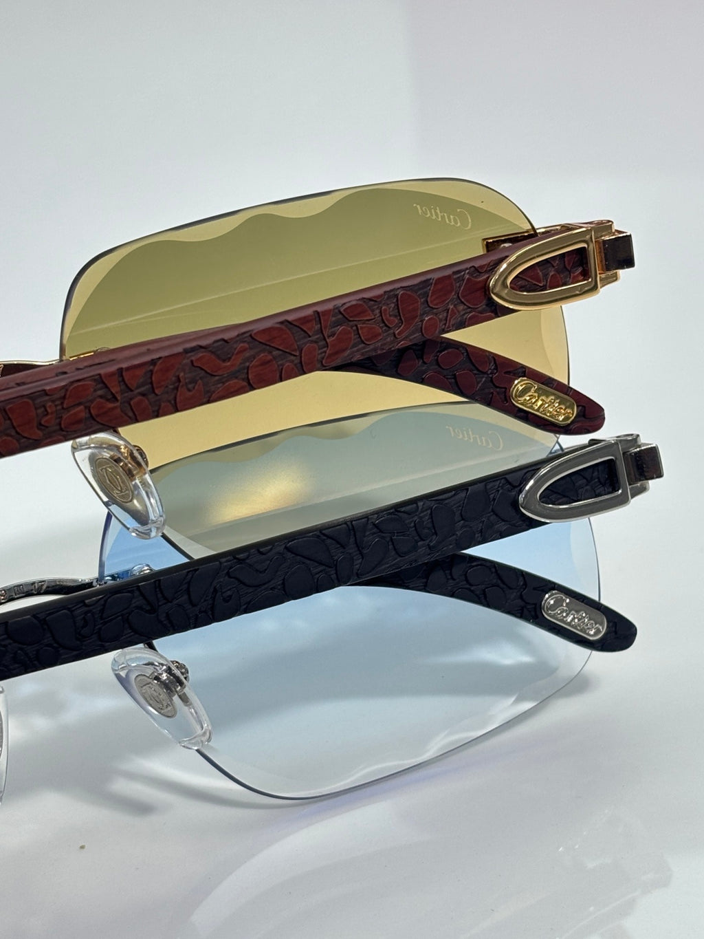 Two eyeglasses with dark patterned frames and tinted lenses