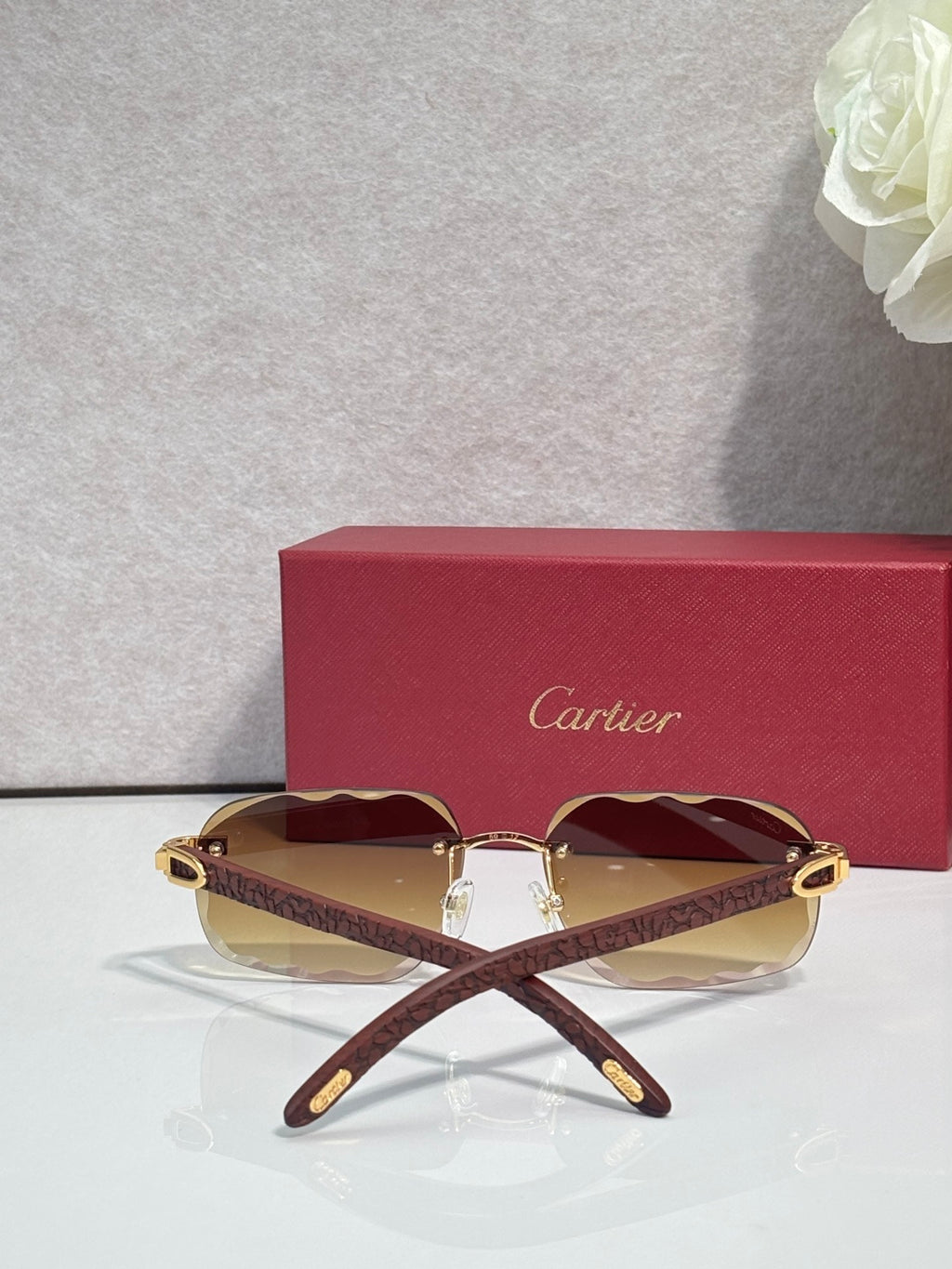 Brown patterned eyeglasses with maroon tinted lenses and gold-tone frame