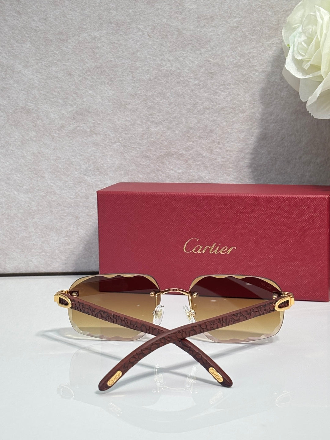 Brown patterned eyeglasses with maroon tinted lenses and gold-tone frame