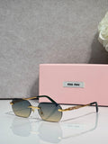 MiuMiu sunglasses with gold metal frame, dark lenses, and jeweled temple detail