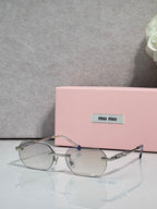 MiuMiu sunglasses with silver metal frame, clear lenses, and jeweled temple detail