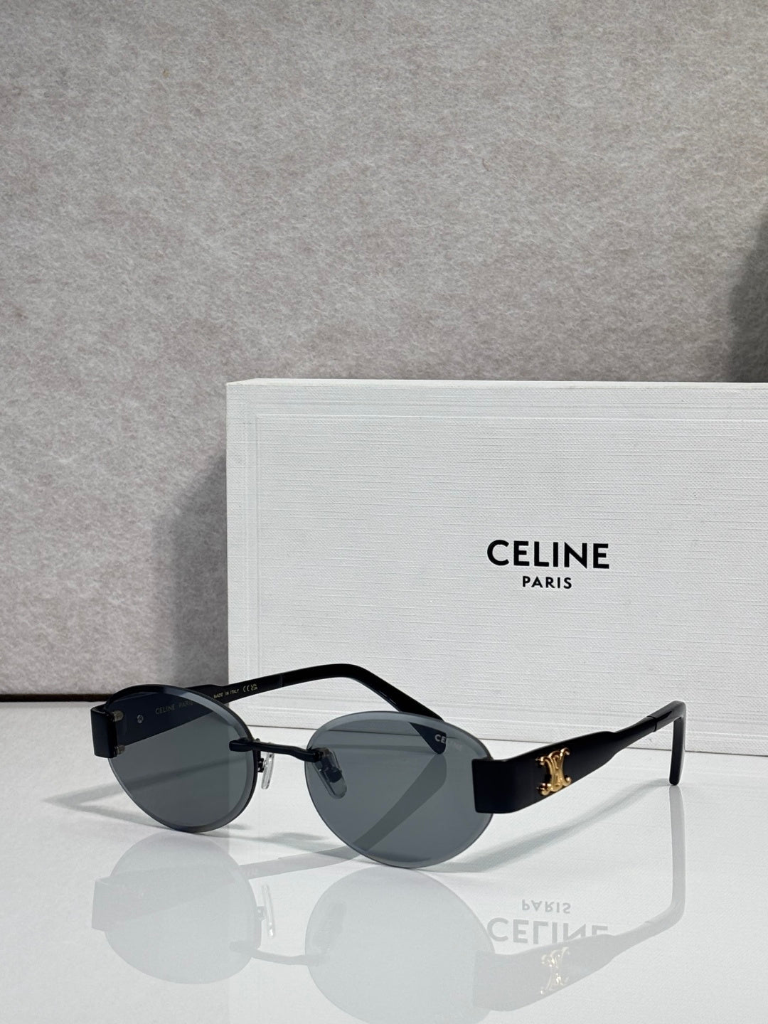 Black round sunglasses with gold-tone hinges and dark gray tinted lenses