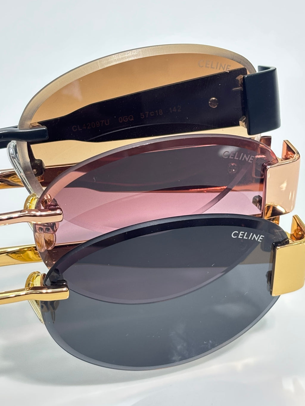 Celine glasses stacked close-up showing navy temples and colored lens interiors