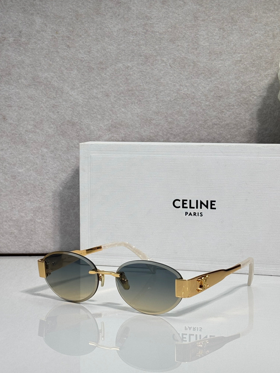 Celine glasses with gold frames, dark green-tinted lenses, thin metal arms