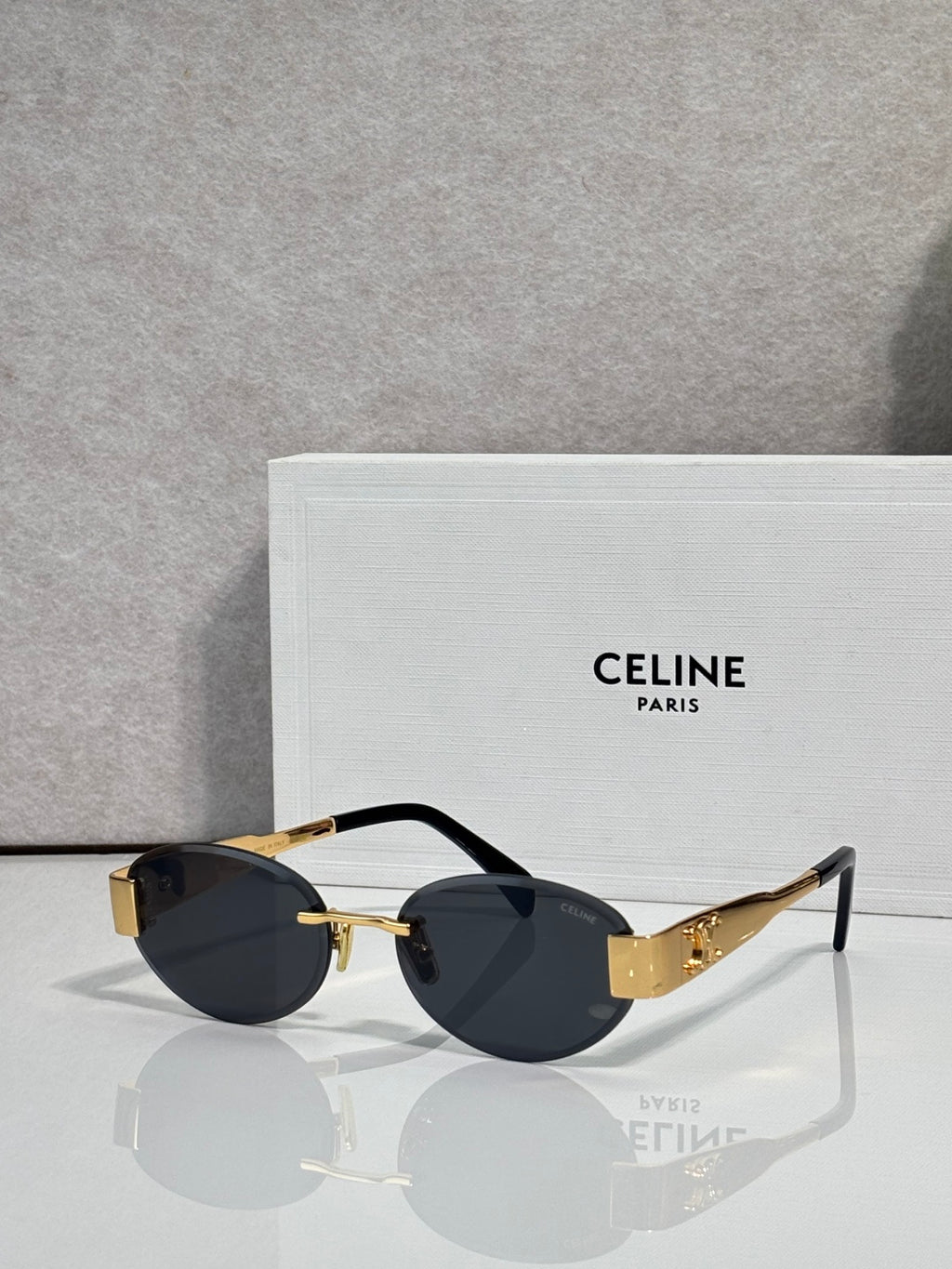 Celine glasses with black frames and dark lenses, gold accents on hinges