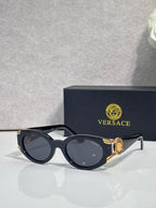 Versace glasses with black oval frames, tinted lenses, gold-tone accents on temples