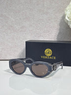 Versace glasses with dark frames, tinted lenses, ornate emblem on temple