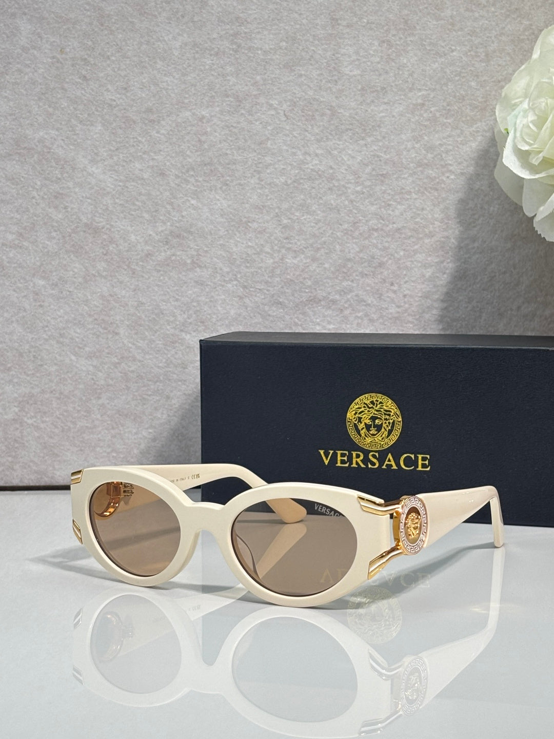 Versace glasses with white round frames, tinted lenses, gold medallion on temple