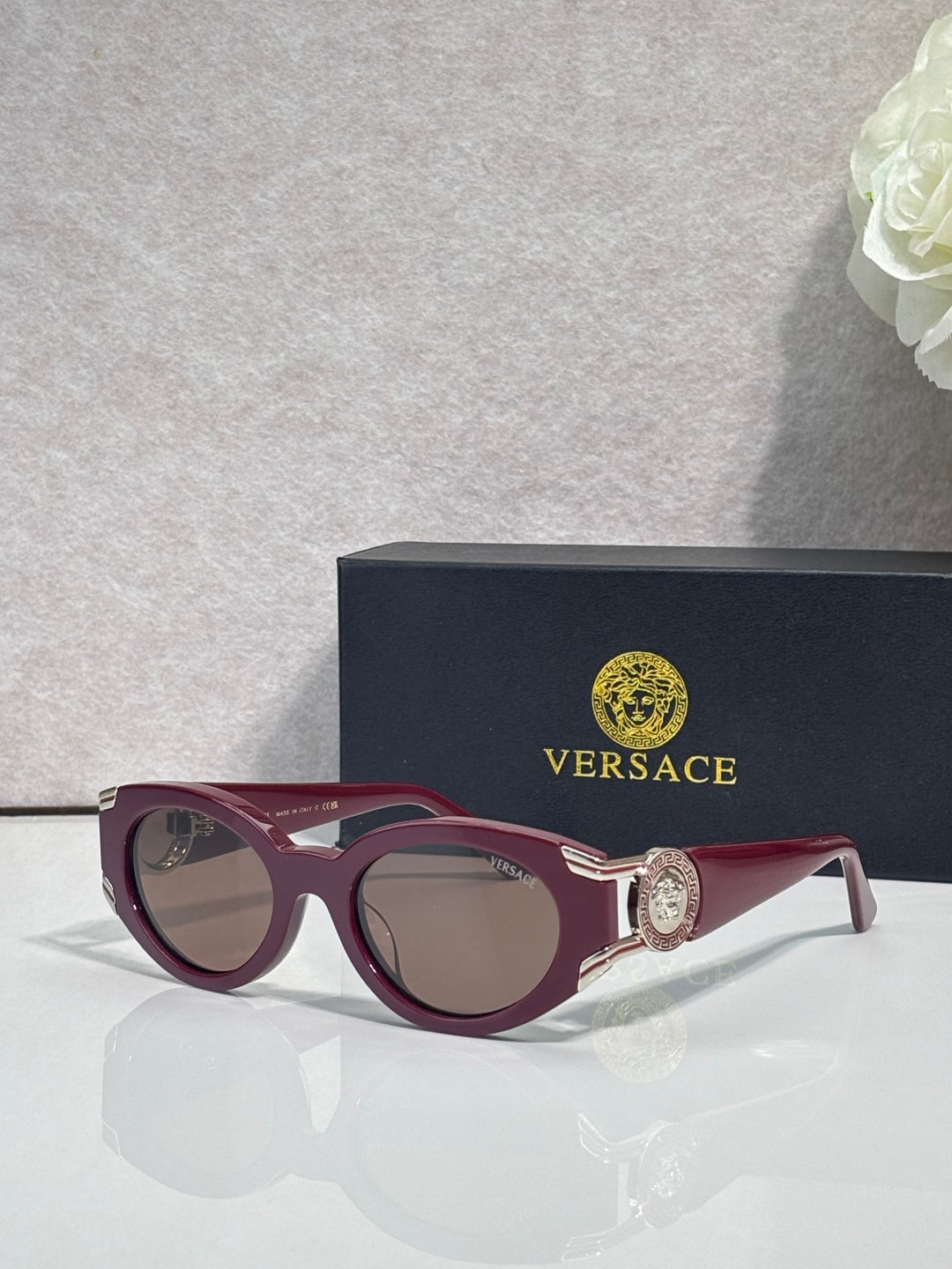 Versace glasses with burgundy round frames and dark lenses, gold emblem on temples