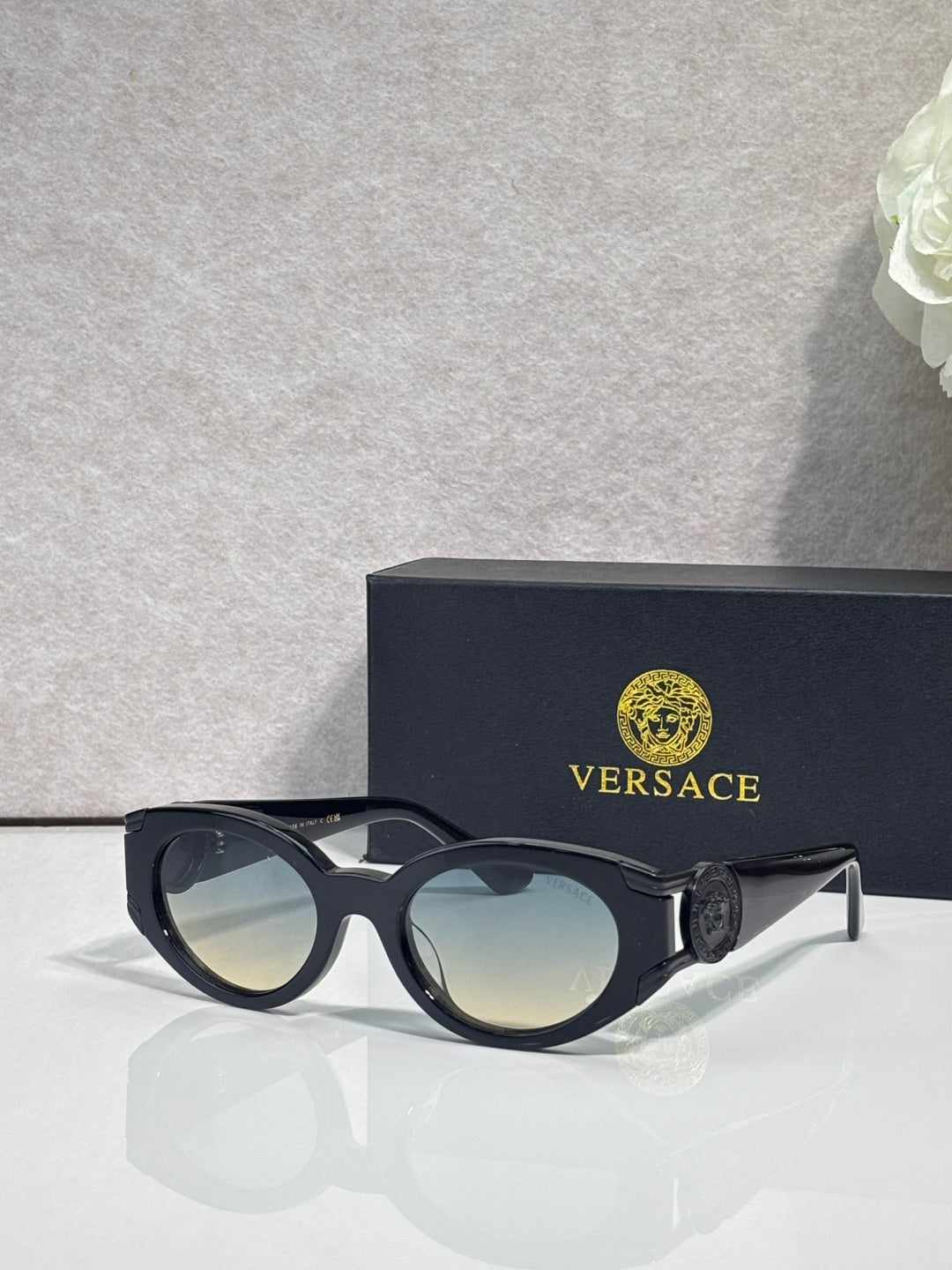 Versace glasses with matte black frames, tinted lenses, dark emblem on temples
