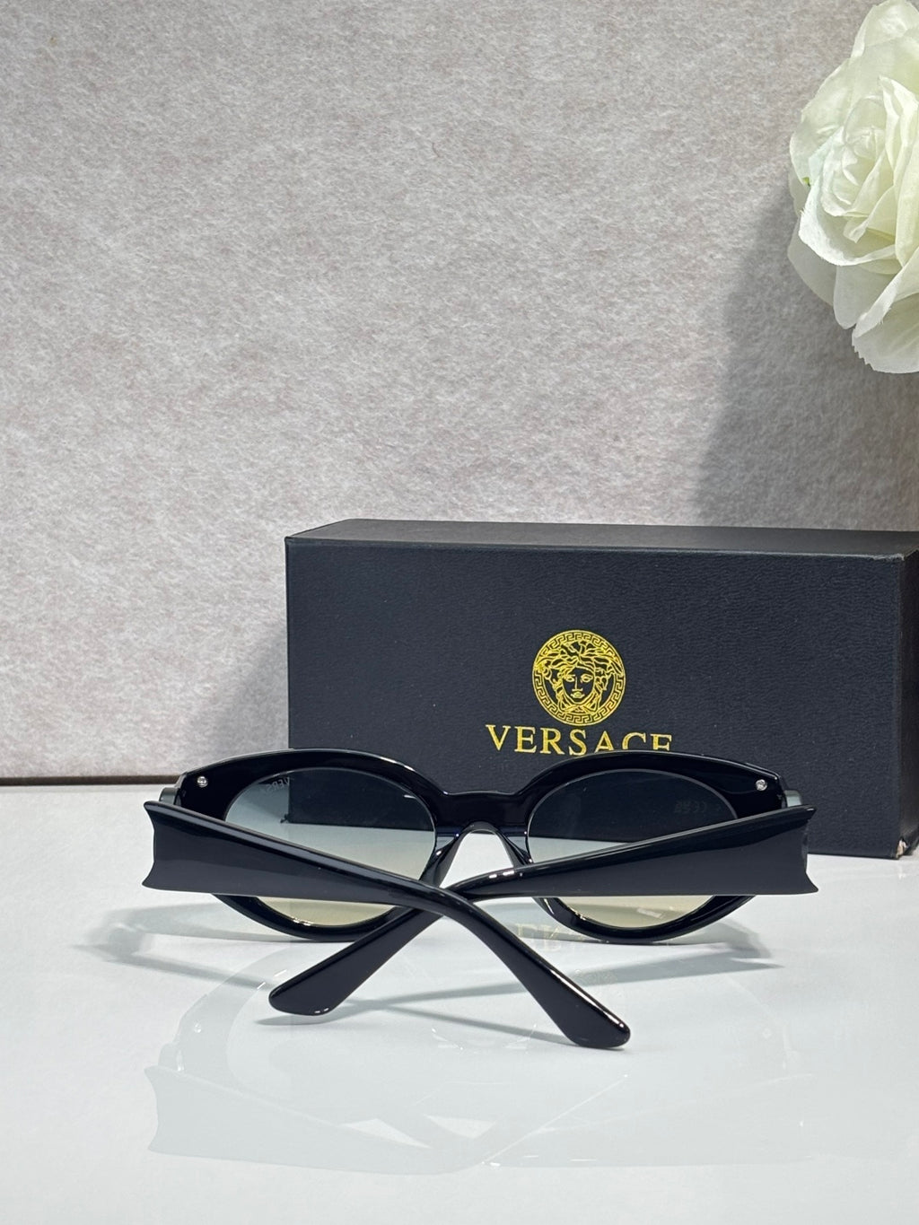 Versace glasses with black frames and tinted lenses, crossed temple design