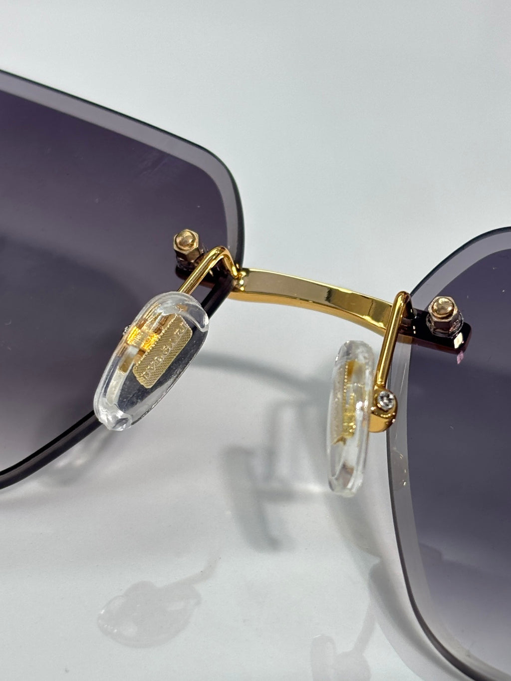 Gold hinge and temple detail on dark-lensed sunglasses