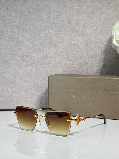 Gold-framed cat-eye sunglasses with amber gradient lenses and butterfly bridge charm
