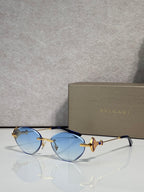 Sunglasses with light blue lenses and gold metal frame, jeweled bow accent