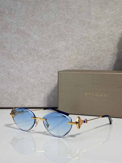 Sunglasses with light blue lenses and gold metal frame, jeweled bow accent