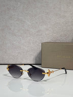 Sunglasses with dark brown lenses and gold metal frame, jeweled bow accent