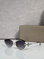 Sunglasses with dark round lenses, black thin metal frame, gold logo detail