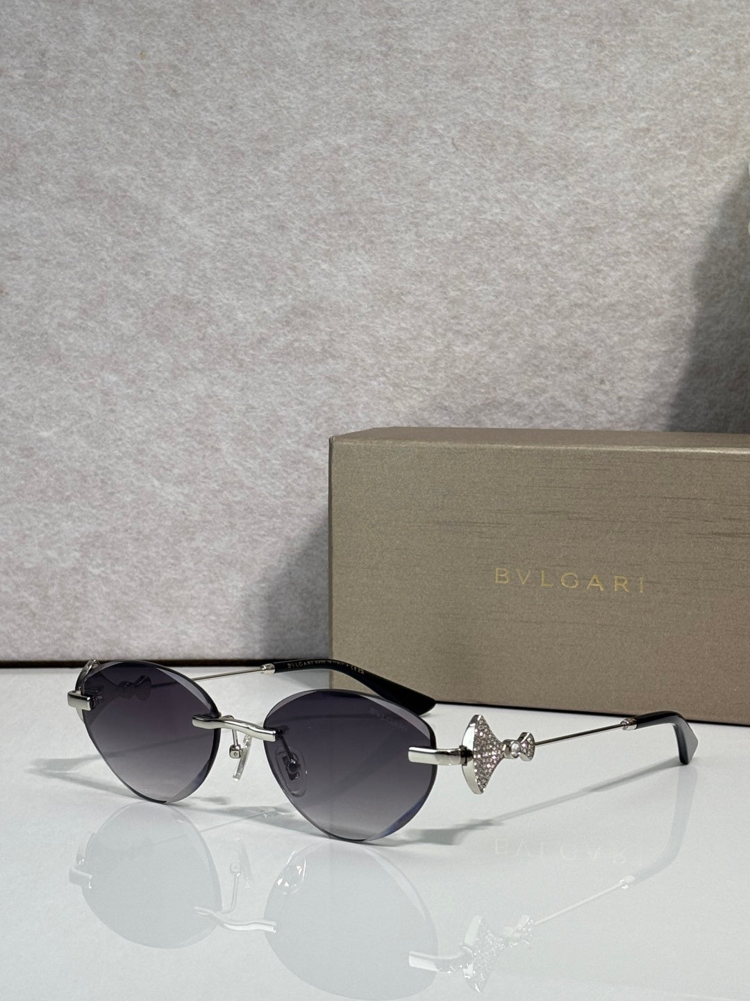 Sunglasses with dark round lenses, black thin metal frame, gold logo detail