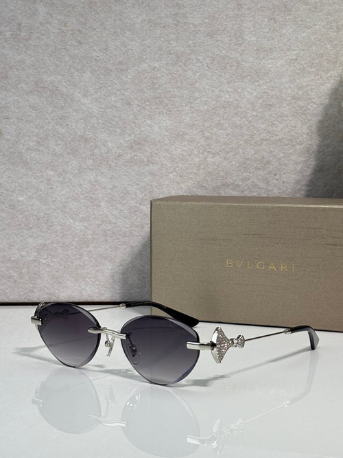 Sunglasses with dark round lenses, black thin metal frame, gold logo detail
