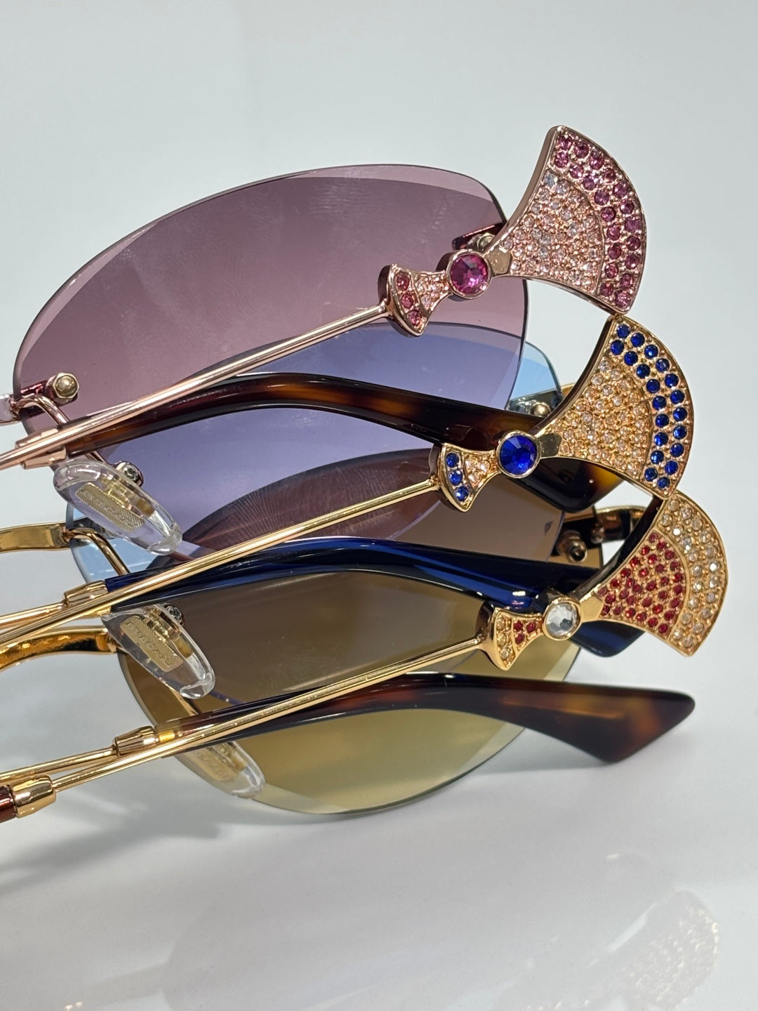 Jeweled sunglasses with layered purple and blue lenses, gold metal frame