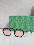 Gucci sunglasses with round black frames and pink mirrored lenses, gold logo