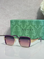 Gucci sunglasses with burgundy frames, gold accents, and tinted lenses