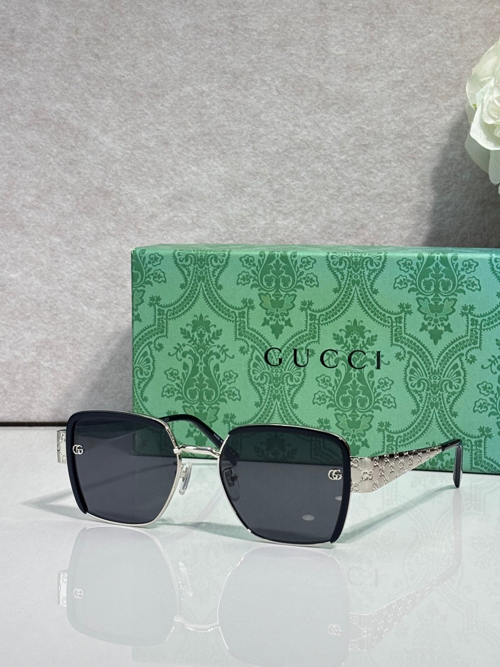 Gucci sunglasses with dark frames, green temples, and tinted lenses