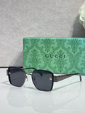 Gucci sunglasses with dark frames, green temples, and tinted lenses