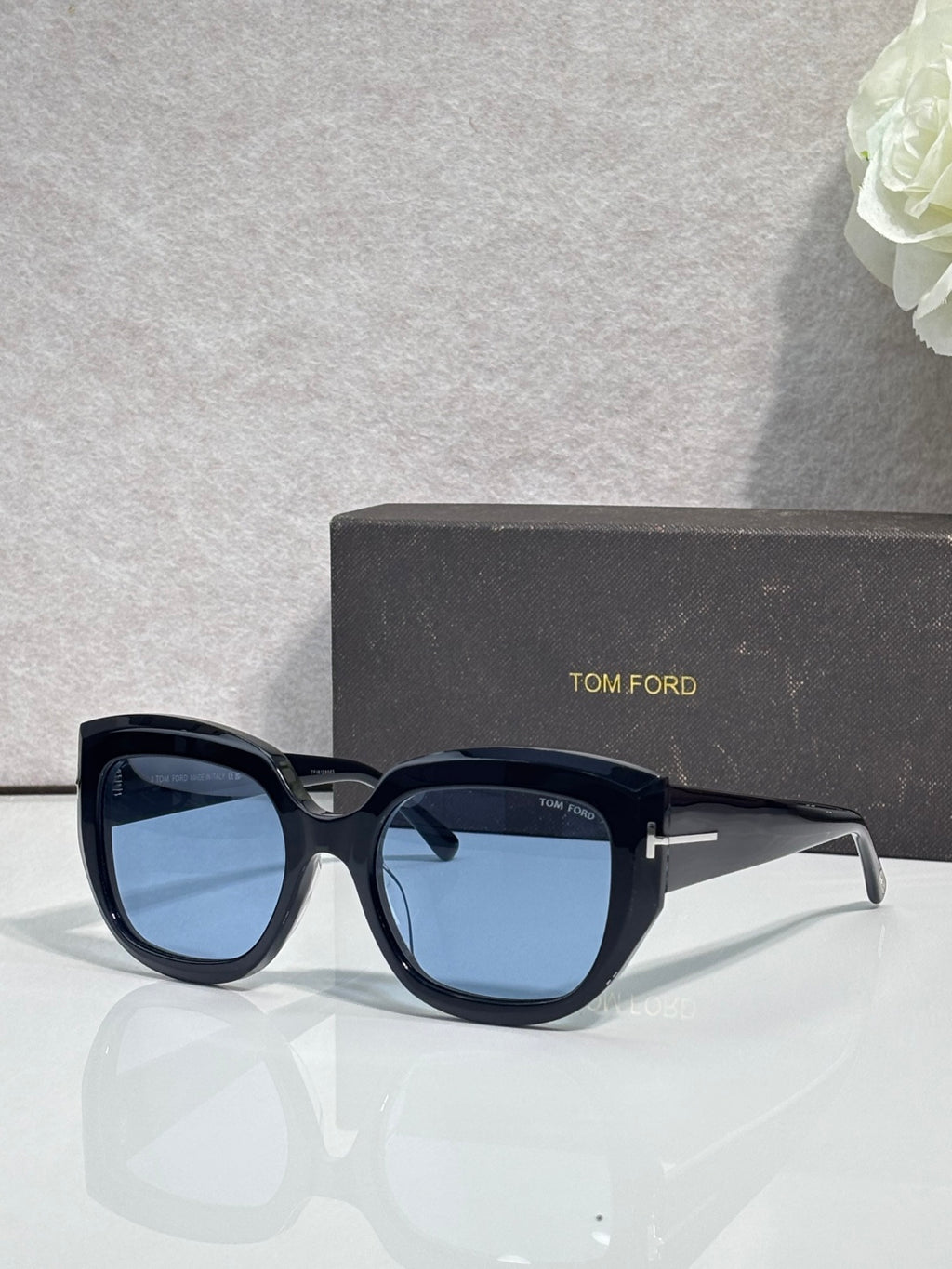 Square sunglasses with dark frames and blue-tinted lenses, TOM FORD temple branding