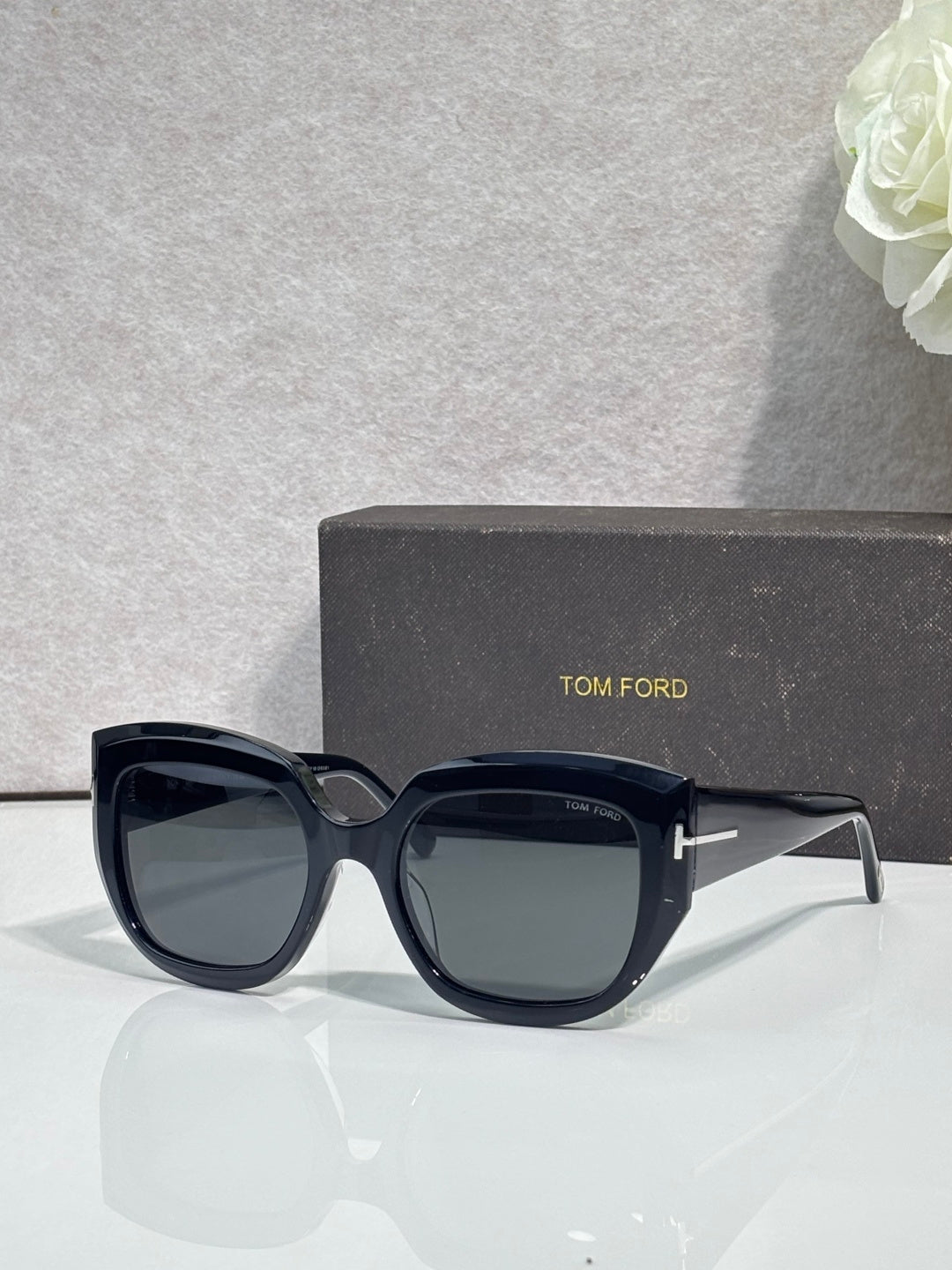 Square sunglasses with navy frames and light gray lenses, TOM FORD temple branding