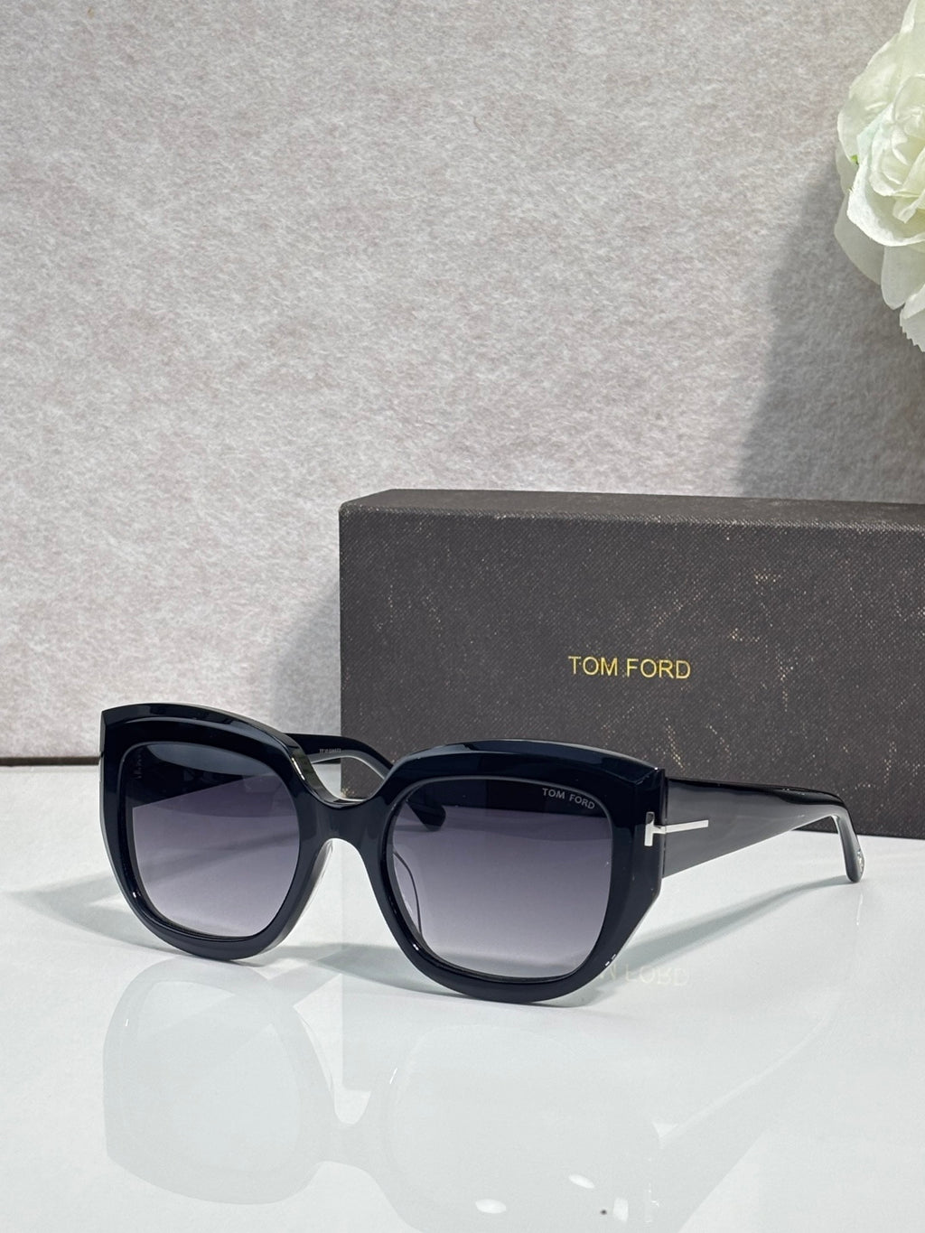 Angled square sunglasses with navy frames and dark gray lenses, TOM FORD temple branding