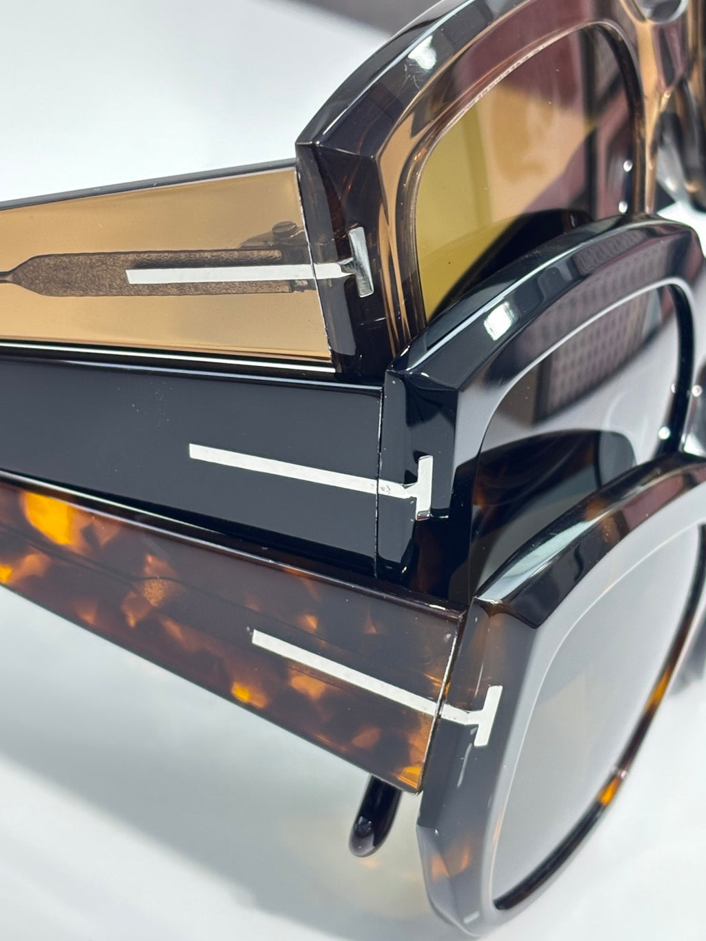 Close-up of tortoiseshell sunglasses with gold-tinted lenses and metal hinge hardware