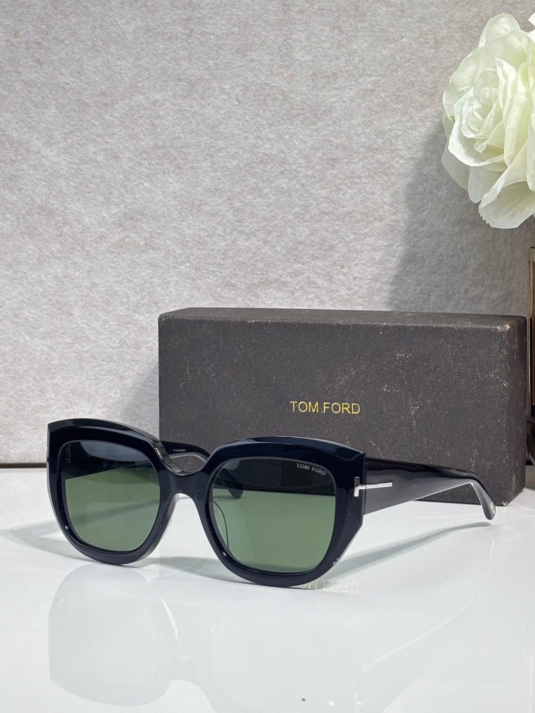 Square sunglasses with dark frames and green-tinted lenses, TOM FORD temple branding