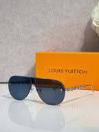 Sunglasses with dark gradient lenses and gold-tone chain detail, rectangular shape