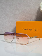 Sunglasses with clear-toned frame edges and gold chain temple, brown gradient lenses