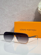 Sunglasses with dark lenses and gold-tone chain detail, aviator-style metal frame