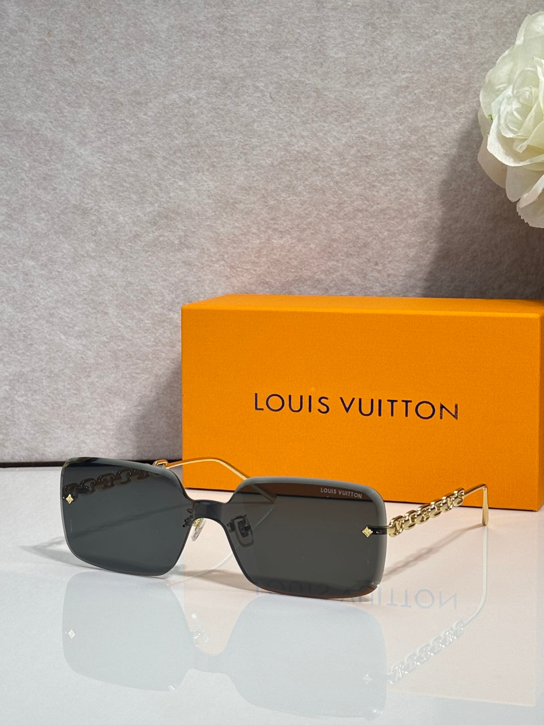 Louis Vuitton square sunglasses, black tinted lenses, gold chain-link temples