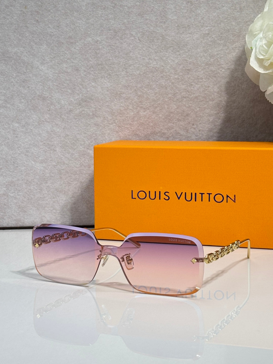 Louis Vuitton square sunglasses, pink tinted lenses, gold chain-link temples