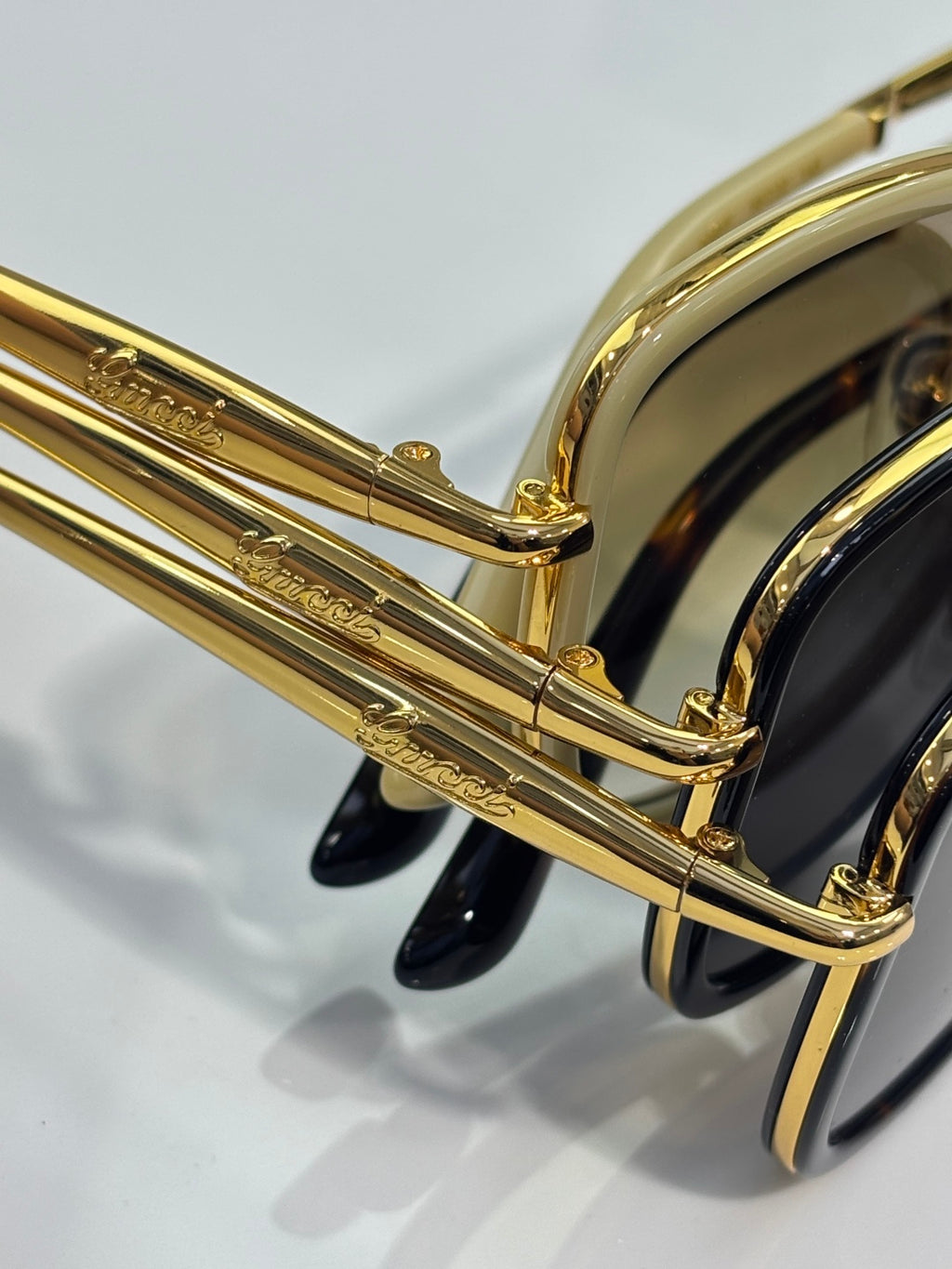Gucci sunglasses temple detail with gold metal arms and dark acetate end pieces
