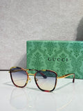 Gucci sunglasses with gold frame, tortoiseshell red-brown rims, and tinted lenses