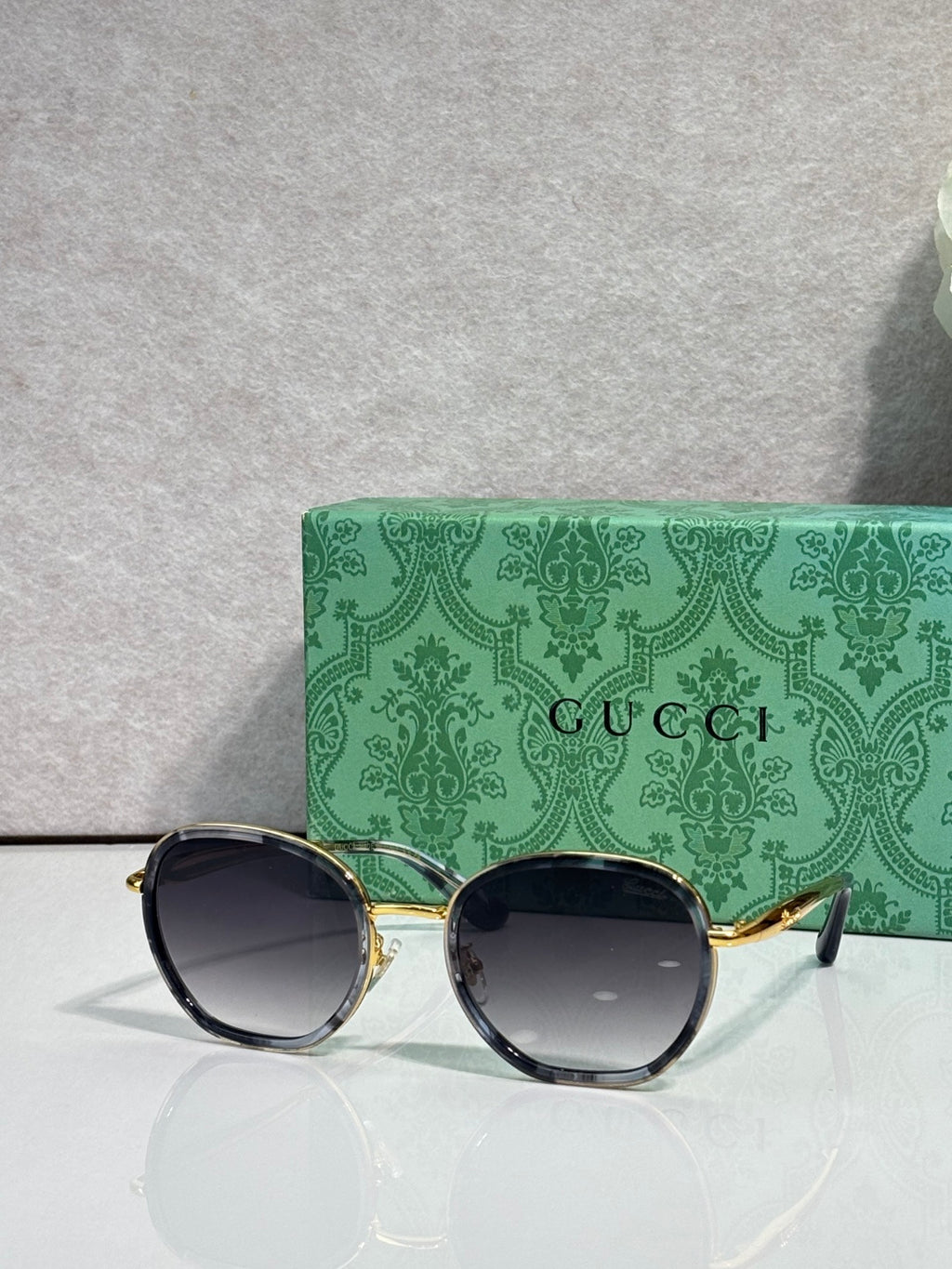 Round sunglasses with dark lenses and gold-tone metal temples, side view.