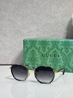 Round sunglasses with dark lenses and gold-tone metal temples, side view.